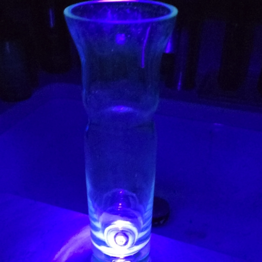This elegant glass bud vase dates from the mid-20th century, approximately 1960s